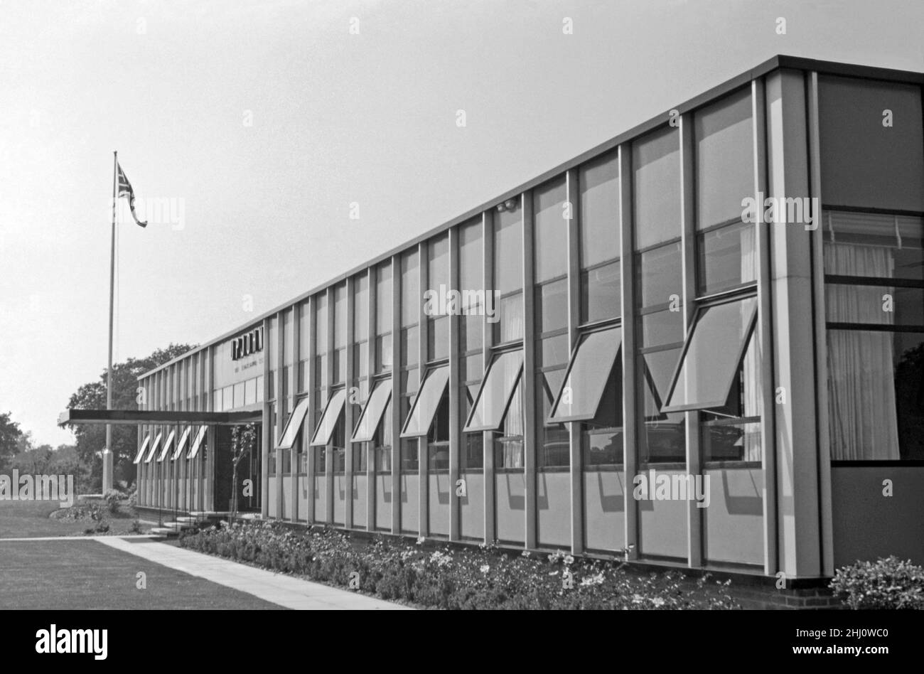 A 1960s photograph of new modern offices and laboratories, for Upjohn, a pharmaceutical company, in Fleming Way, Crawley ‘New Town’, West Sussex, England, UK – it opened in 1957. The Union flag is raised on the flagpole. The area has undergone massive changes and modernisation since this period. Upjohn became Pharmacia and Upjohn – the company was owned by Pfizer from 2015 until 2020. In 2020 the company merged with Mylan to form Viatris. This image is from an old amateur black and white transparency – a vintage 1960s photograph. Stock Photo