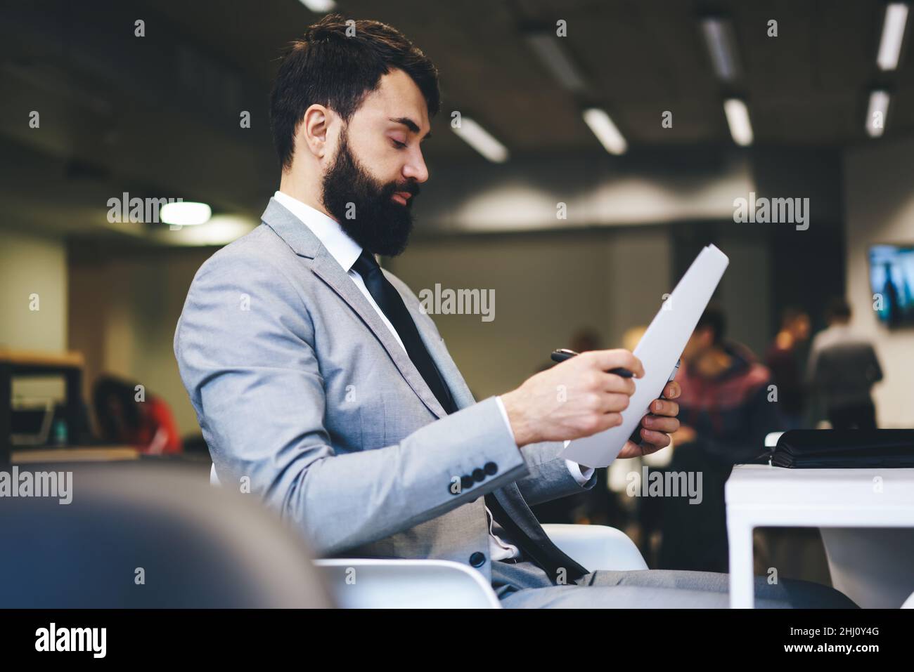 Focused entrepreneur reading documents in office Stock Photo