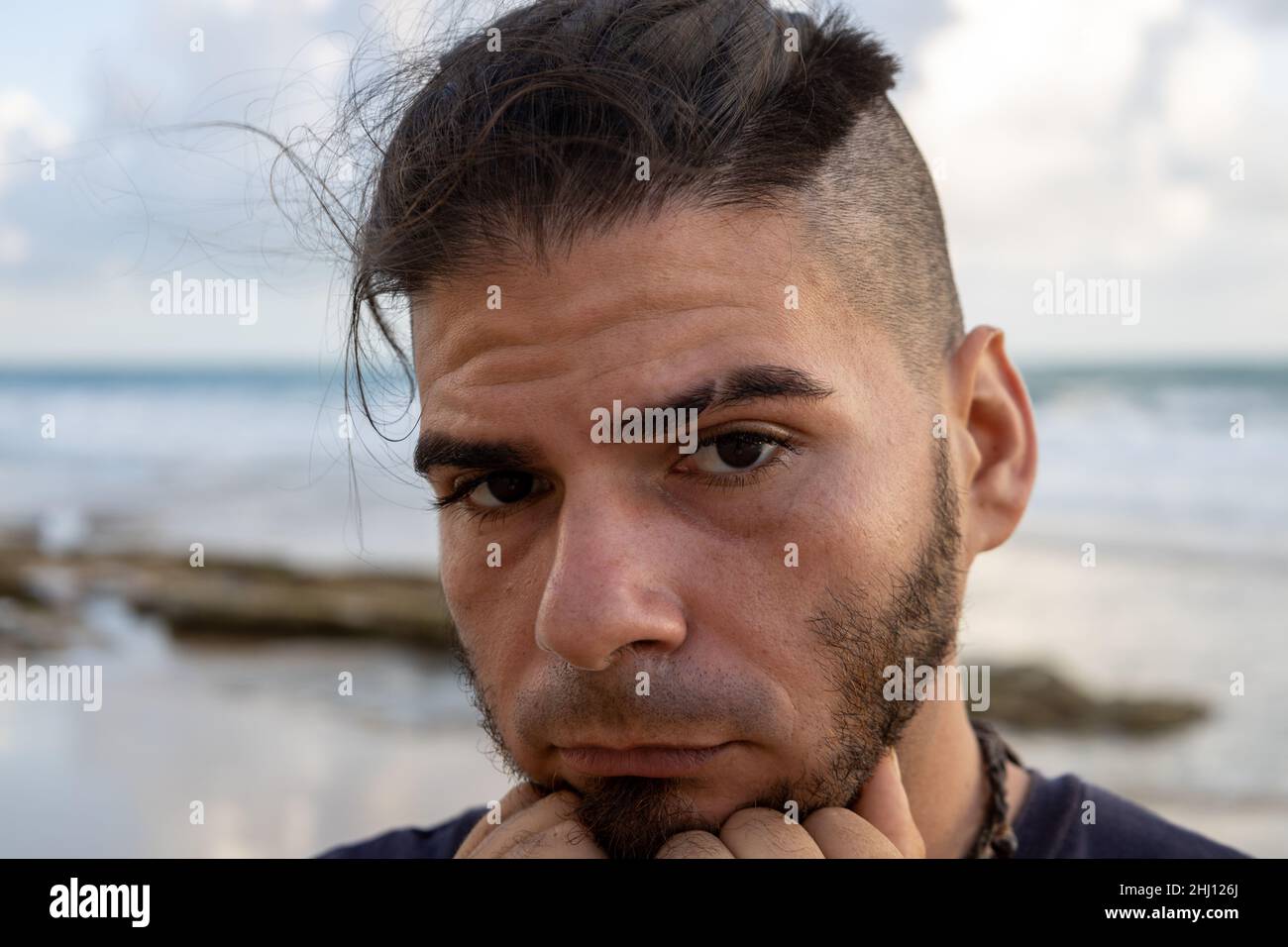 Middle-aged white man looking worried on the beach. Burn out concept. Stock Photo