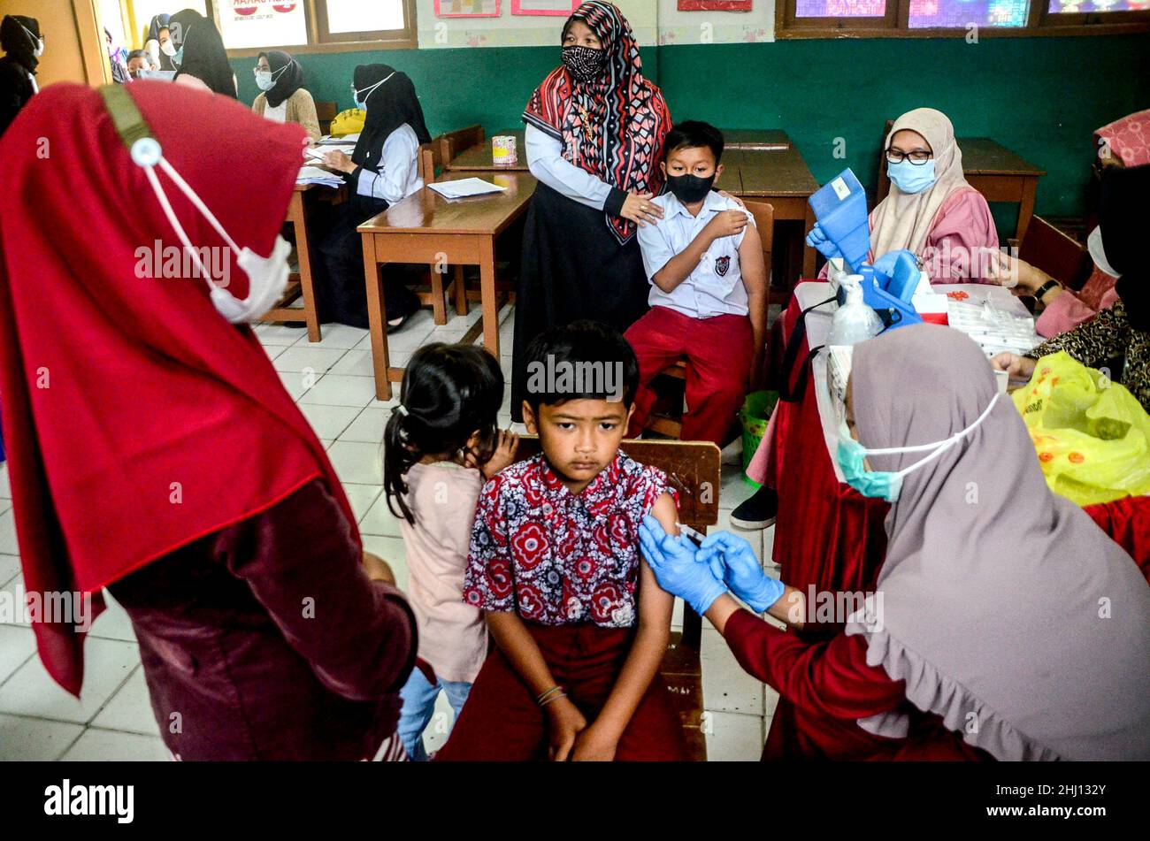 Bogor, Indonesia. 26th Jan, 2022. A health worker administers a dose of COVID-19 vaccine to a boy during vaccination for children aged 6 to 11 in Bogor, West Java, Indonesia, Jan. 26, 2022. Credit: Sandika Fadilah/Xinhua/Alamy Live News Stock Photo