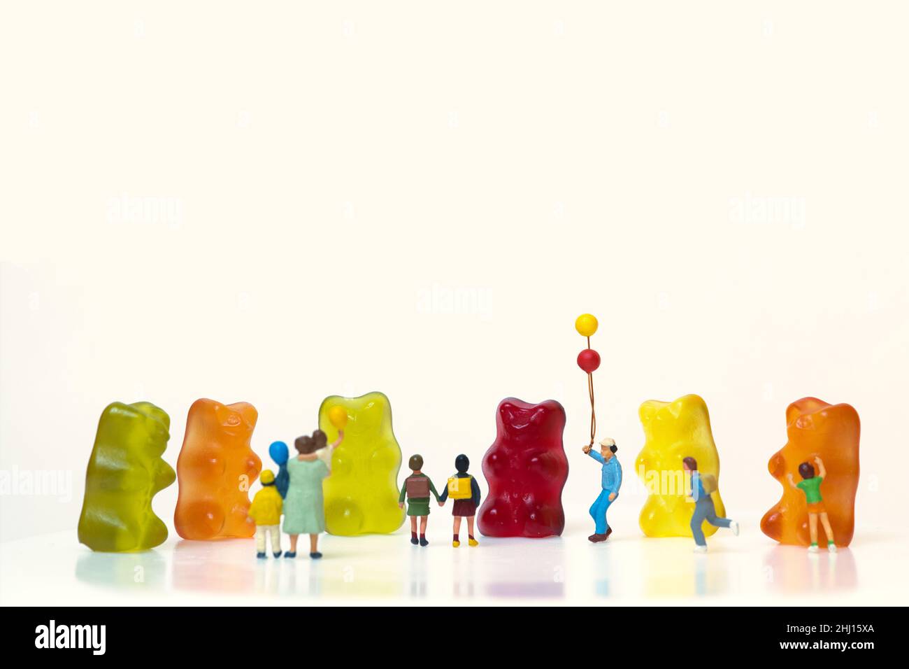 Happy children in front of colorful gummy bears Stock Photo