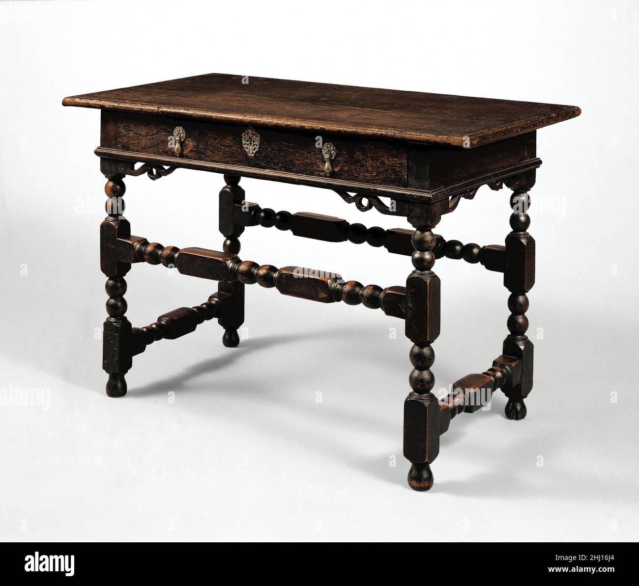 Joined table with drawer 1690–1710 American The turnings of this sophisticated and elegant table mark it as having been made in Boston. The cast-brass hardware on the drawer includes an escutcheon with a cherub’s head—a stylish touch seldom found on American furniture. The table would have been used in a parlor or dining space as a side table and would have been accompanied by similarly turned upholstered chairs, such as the Turkey-work chair (52.77.51). Joined table with drawer  8072 Stock Photo