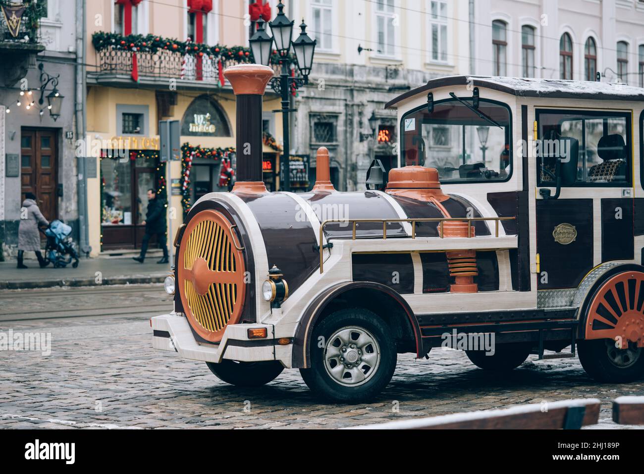 Lviv, Ukraine - January 19, 2022 : Closeup view of Lviv sightseeing train on snowy street. Christmas winter tourist season in Lviv Stock Photo