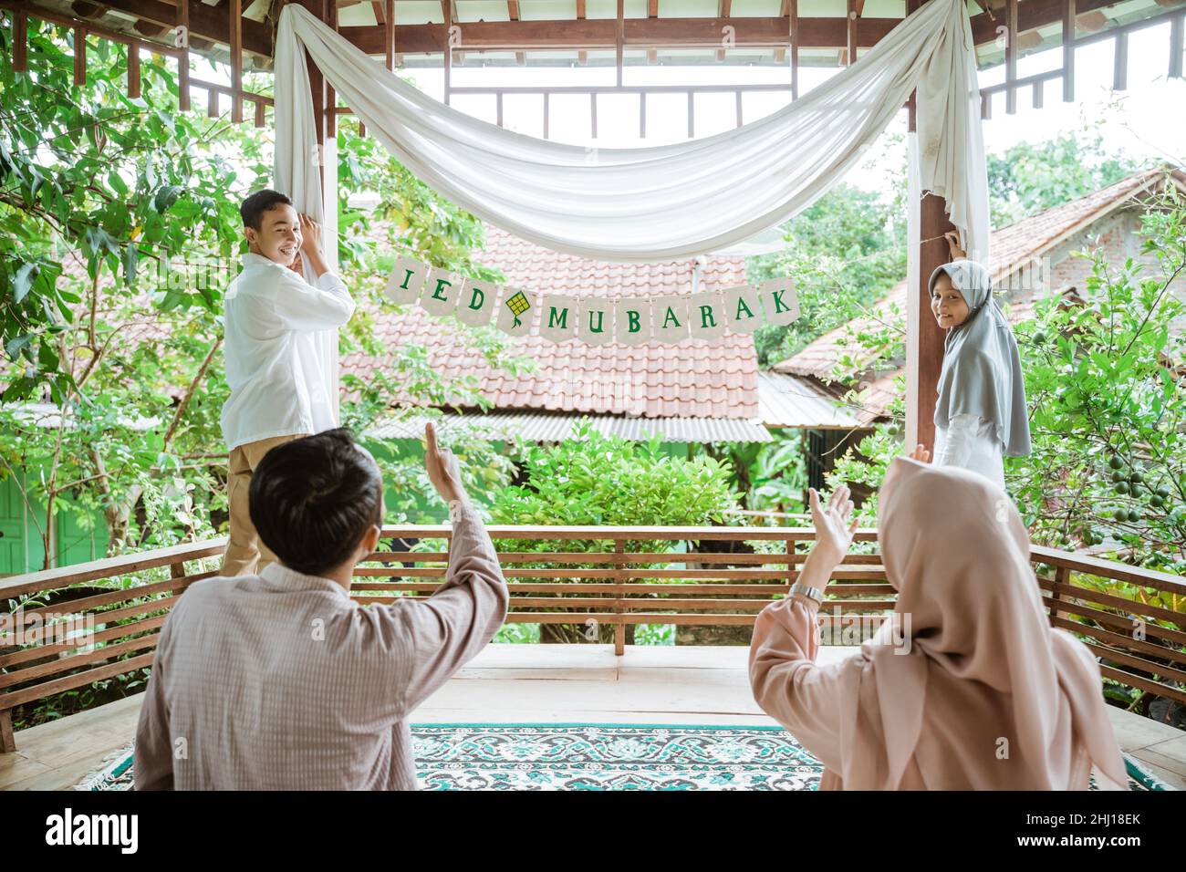 Two children put up a paper flag chain decoration Stock Photo