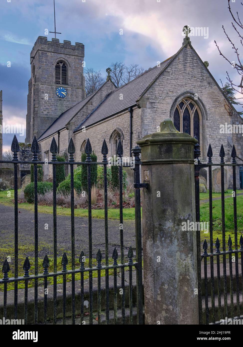 Behind sturdy railings, St Nicholas Church. West Tanfield Stock Photo