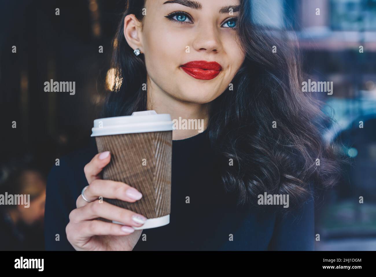 Crop young female drinking hot coffee in cafeteria Stock Photo