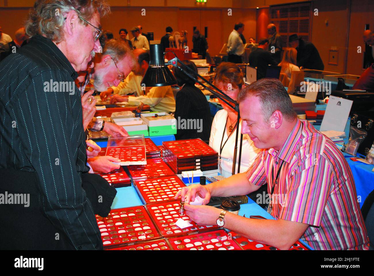 A coin dealer & buyer discuss antique gold coins, at the British Numismatic Trade Association's Coinex, coin collector's numismatist's show/event 2007 Stock Photo