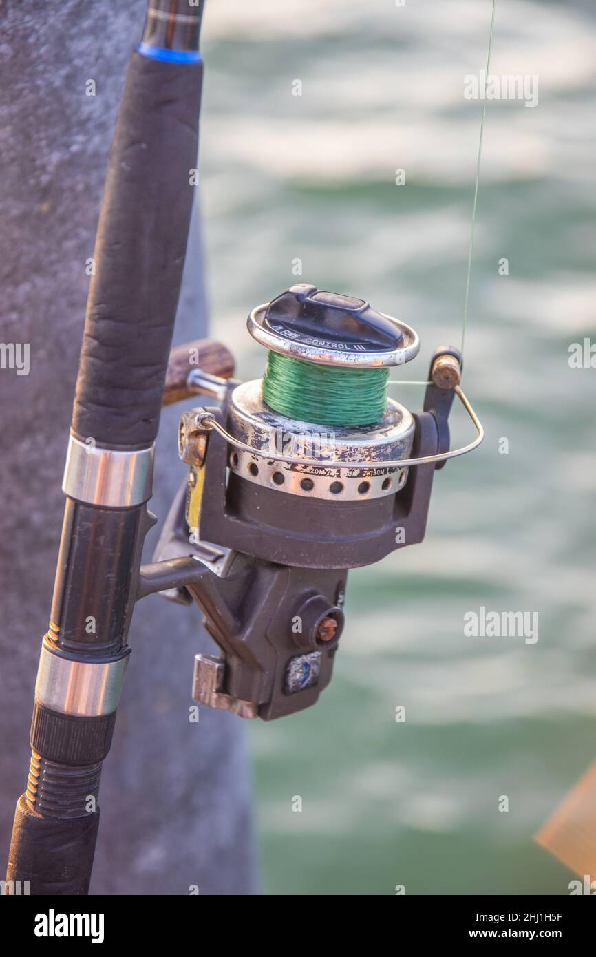 The crank of a fishing rod with reel foot, reel seat, spool, coiled