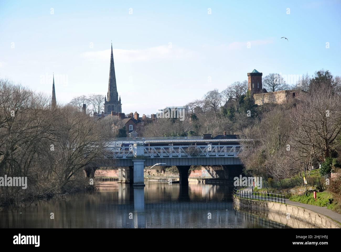 A town scape image of Shrewsbury showing the river,  railway bridge of the station, Laura's Tower and the twin spires in the background Stock Photo