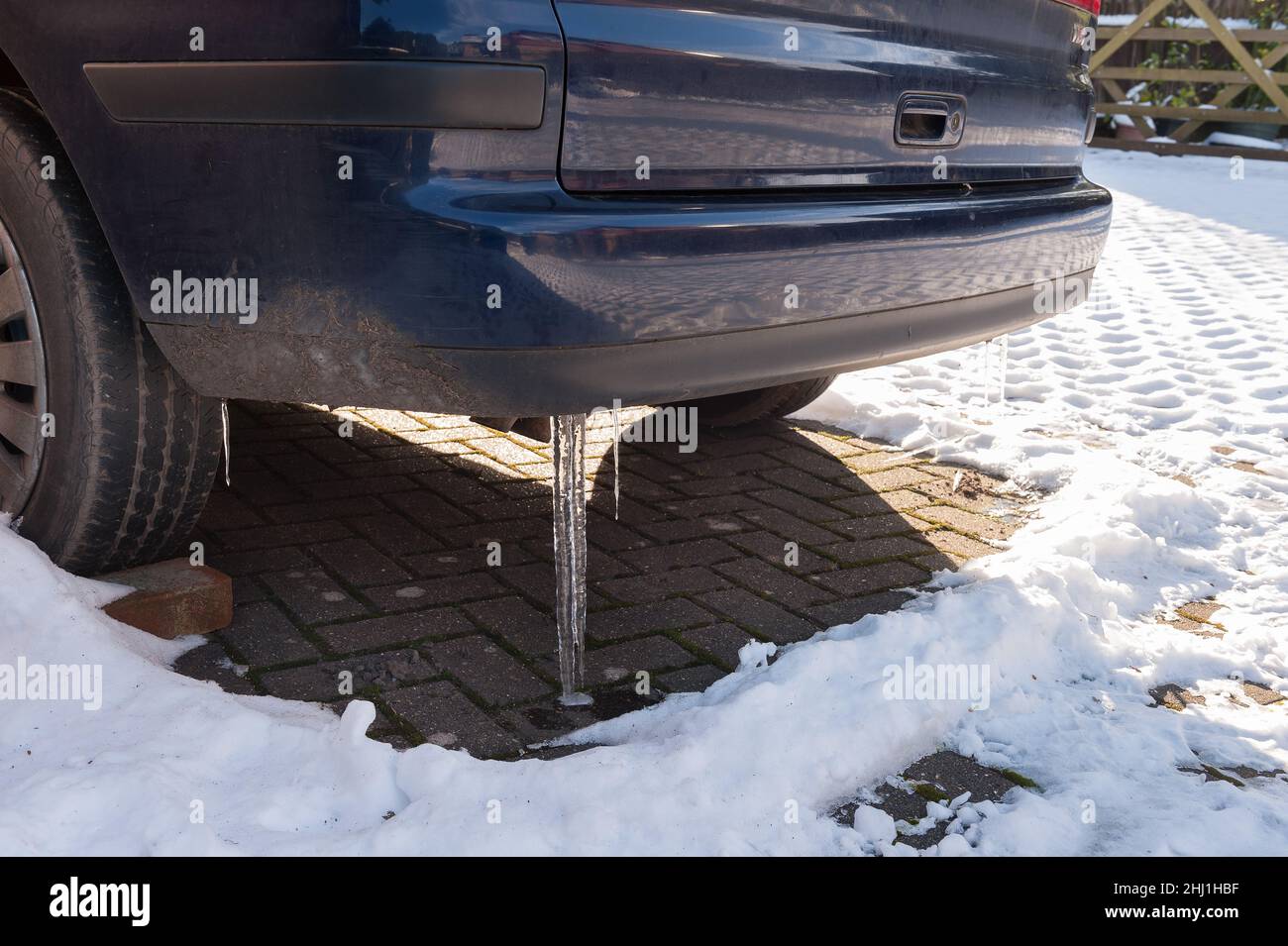 Stationary icebound vehicle with flat battery and icicles forming from