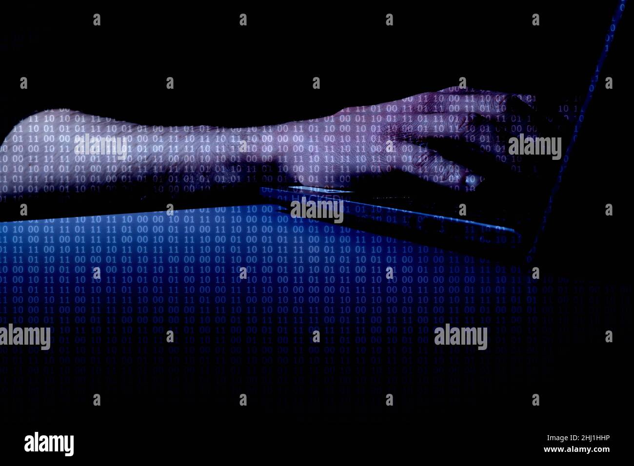 Hacked (DARK) - Hands at computer with binary code overlay with the word 'HACKED' at centre of image Stock Photo