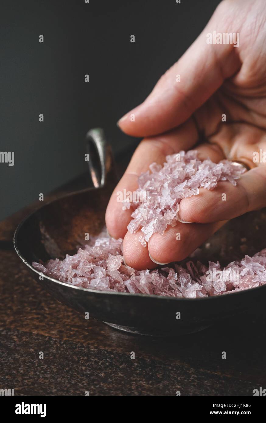 Flakes of pink wine salt in a woman's hands Stock Photo