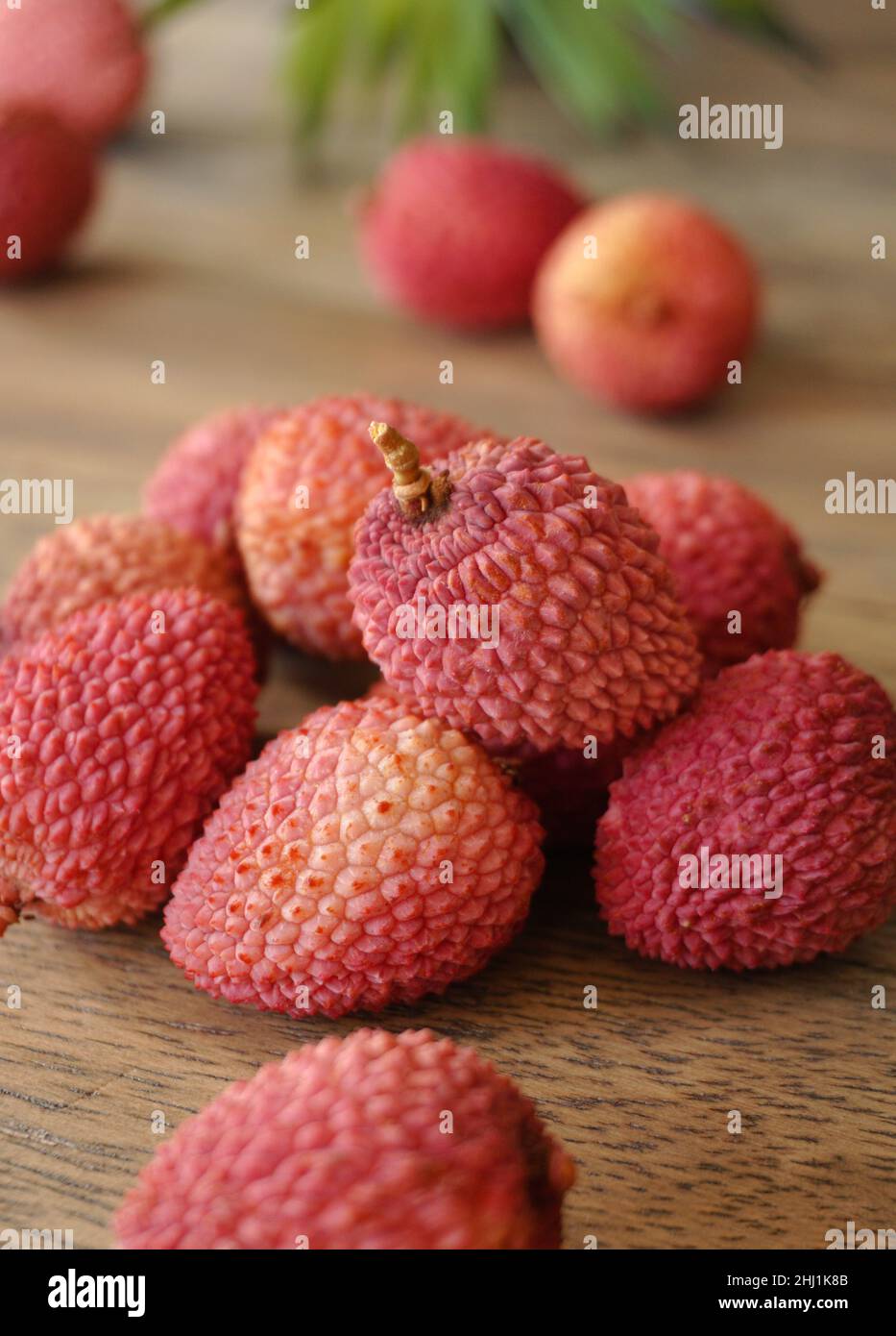 Pink lychees on a wooden background Stock Photo