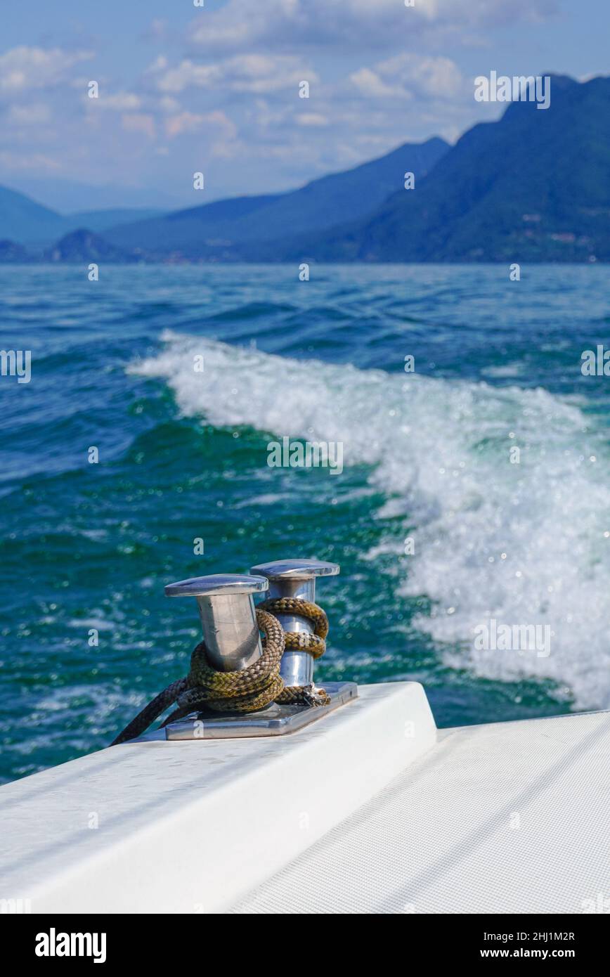 The back of the yacht against the background of waves, mountains, and the brightly colored sea Stock Photo