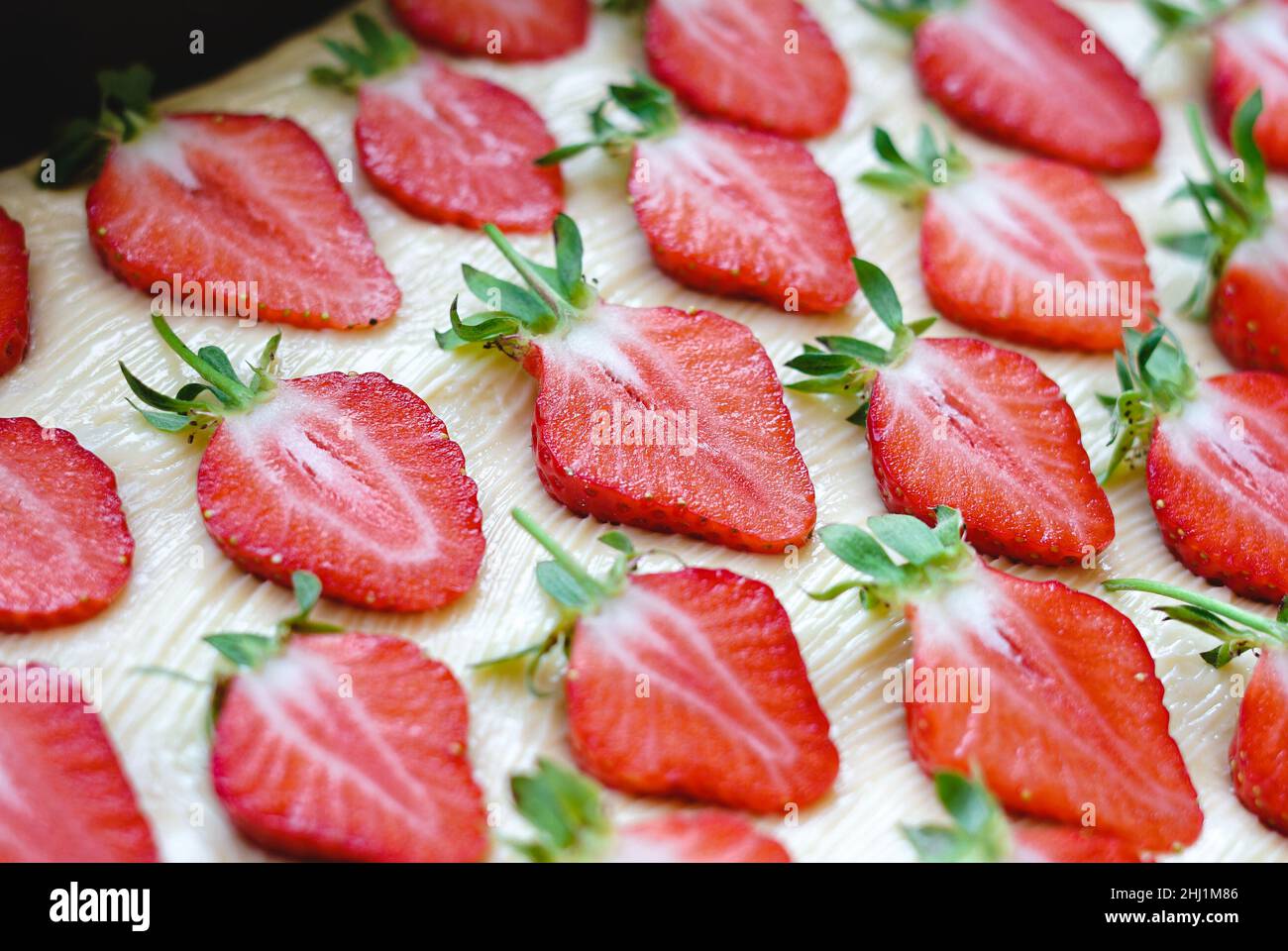Many sliced strawberries on a light background Stock Photo