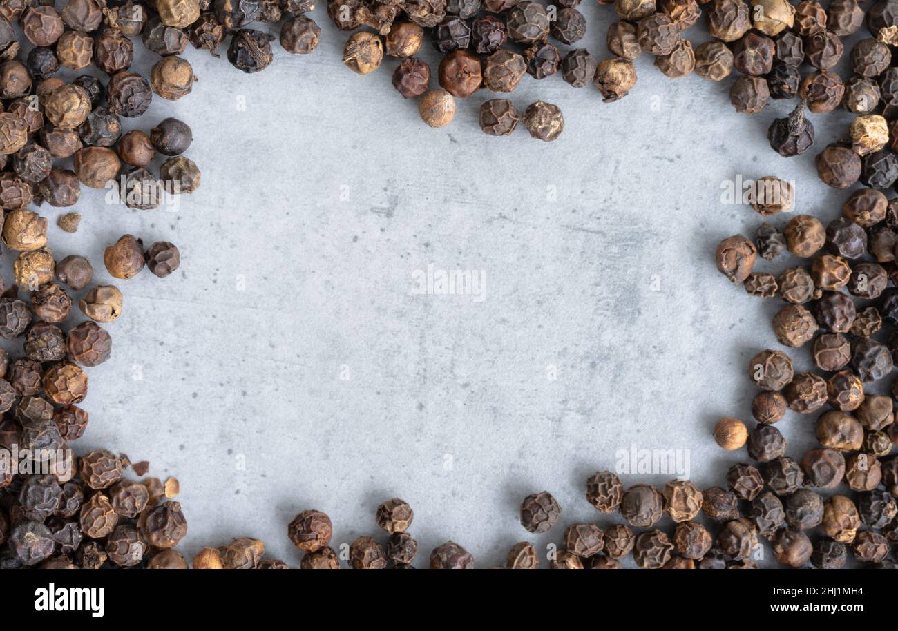 Black pepper frame on a gray background, top view Stock Photo