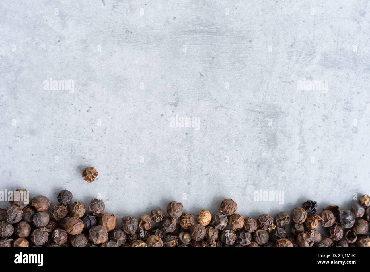 Background with black pepper on the bottom, close-up Stock Photo
