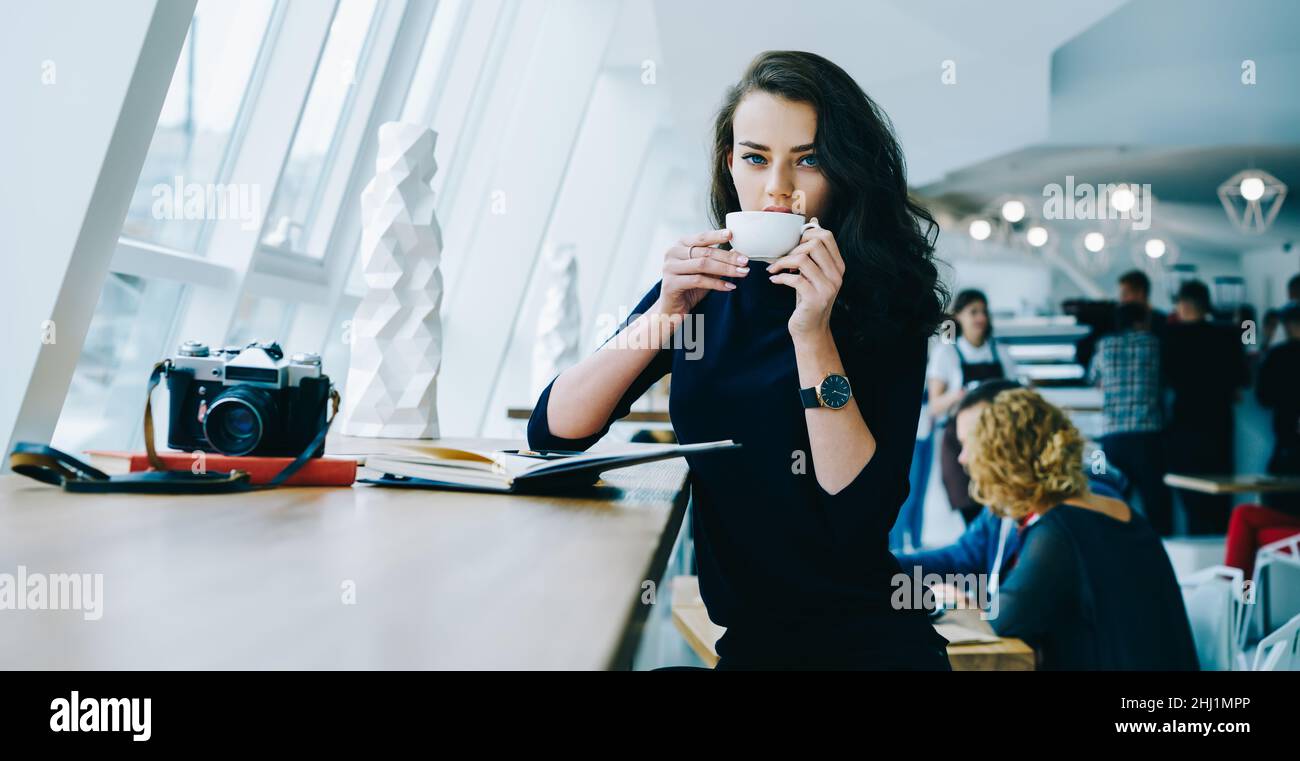 Charming woman with cup of coffee and photo camera Stock Photo
