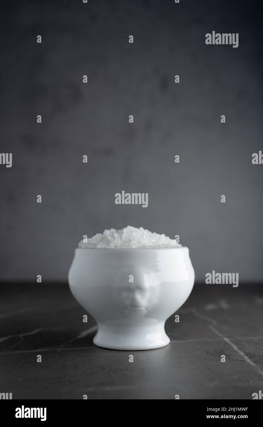 Sea salt in an unusual white ceramic bowl, with free space on top Stock Photo