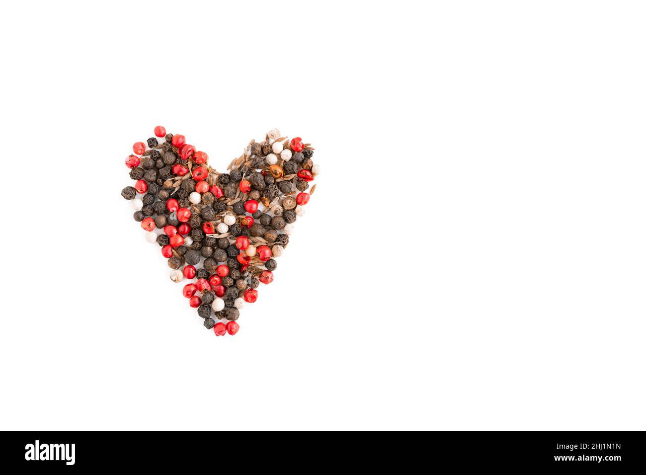 Cumin, pink pepper and heart-shaped black pepper on white background, isolated spices Stock Photo