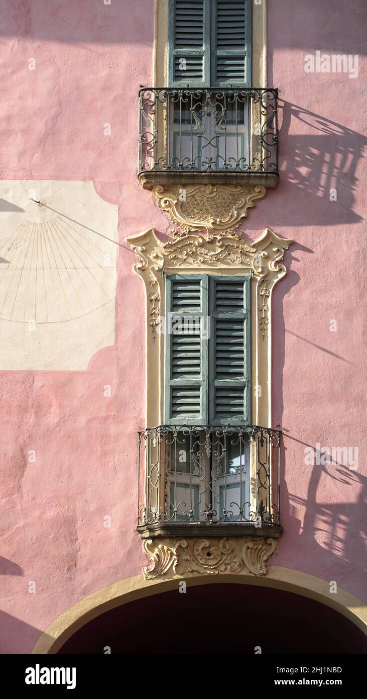 Balcony door with wooden shutters on a pink house in Italy Stock Photo