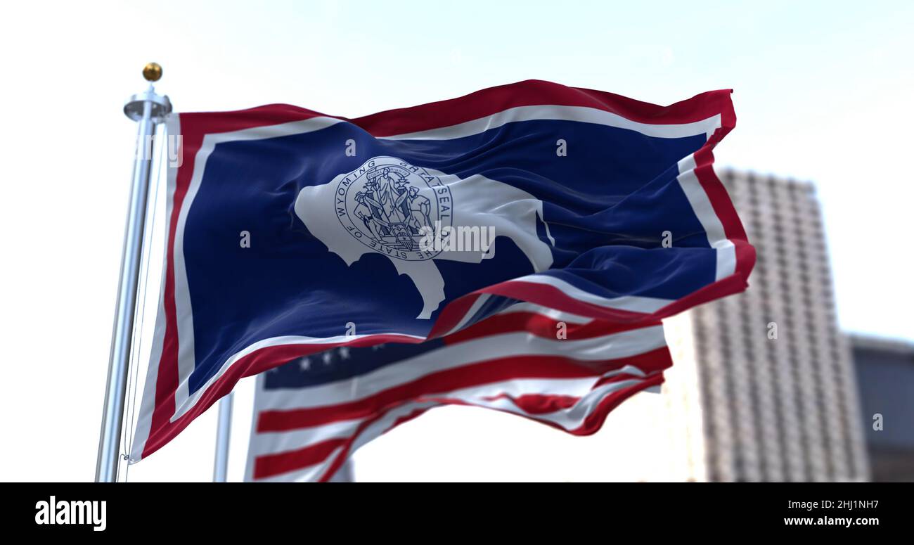 the flag of the US state of Wyoming waving in the wind with the American flag blurred in the background. Wyoming was admitted to the Union on July 10, Stock Photo