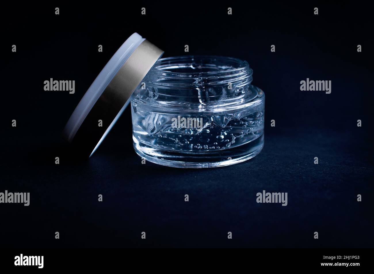transparent jar with moisturizing cream with hyaluronic acid on a black background Stock Photo