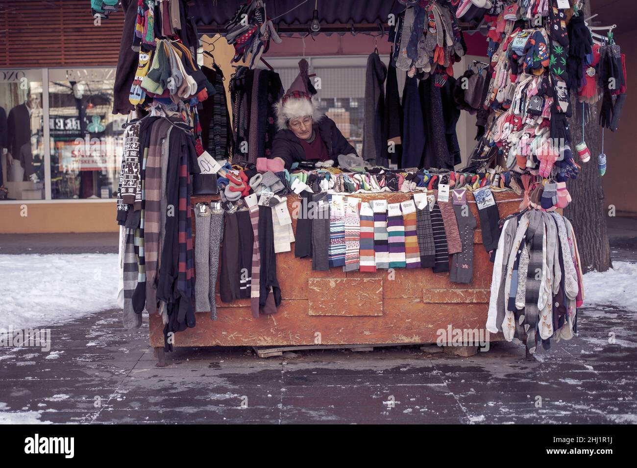 Belgrade, Serbia, Jan 23, 2022: A saleswoman sitting behind a street stand with socks Stock Photo