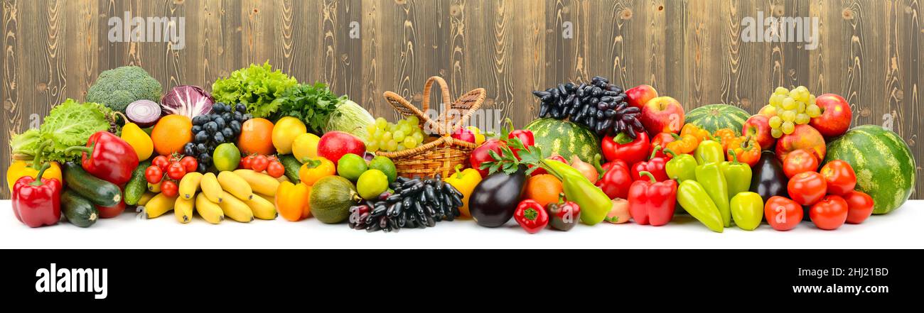 Panoramic collage of ripe, juicy fruits, berries and vegetables on wooden background. Stock Photo
