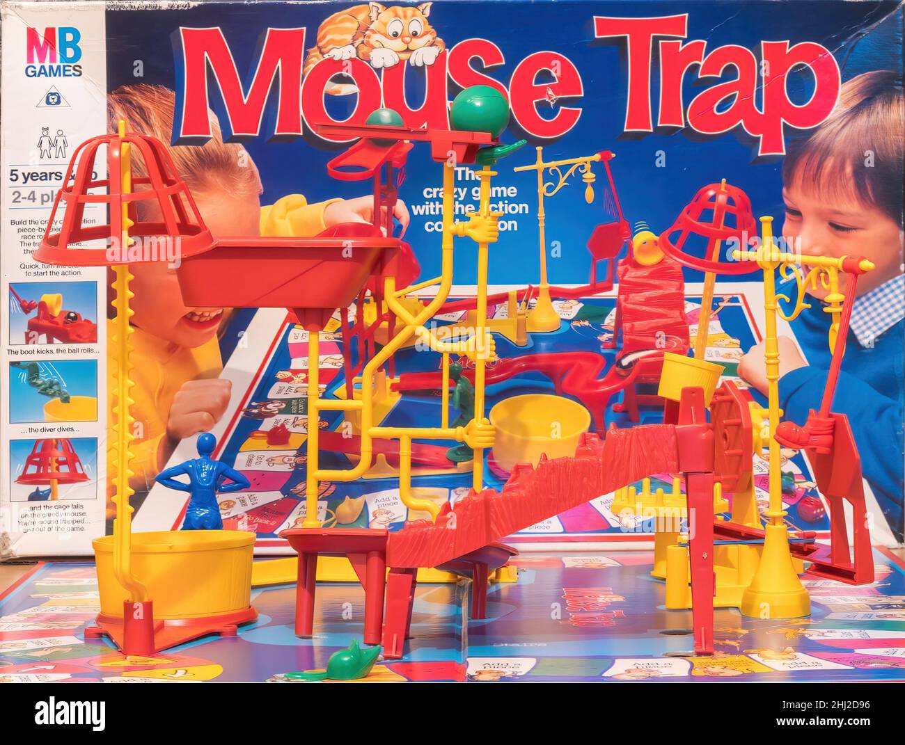 A view of the fully assembled Mouse Trap board game with the MB Games  box the game comes in, in the background. Stock Photo