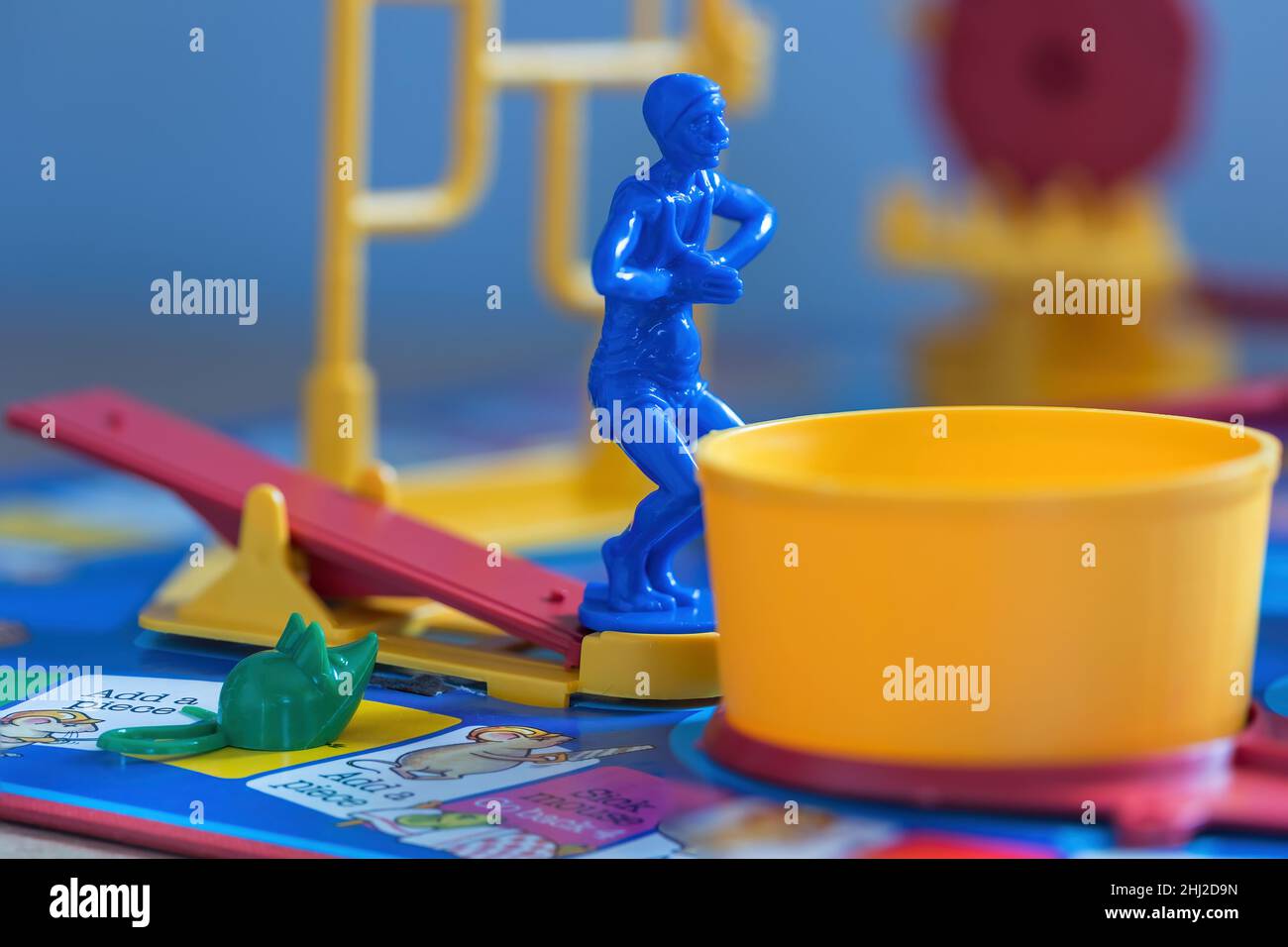 A close up shot of the blue diver standing on the See-Saw and a green mouse on the board. The diver is waiting to dive into the yellow tub. Stock Photo