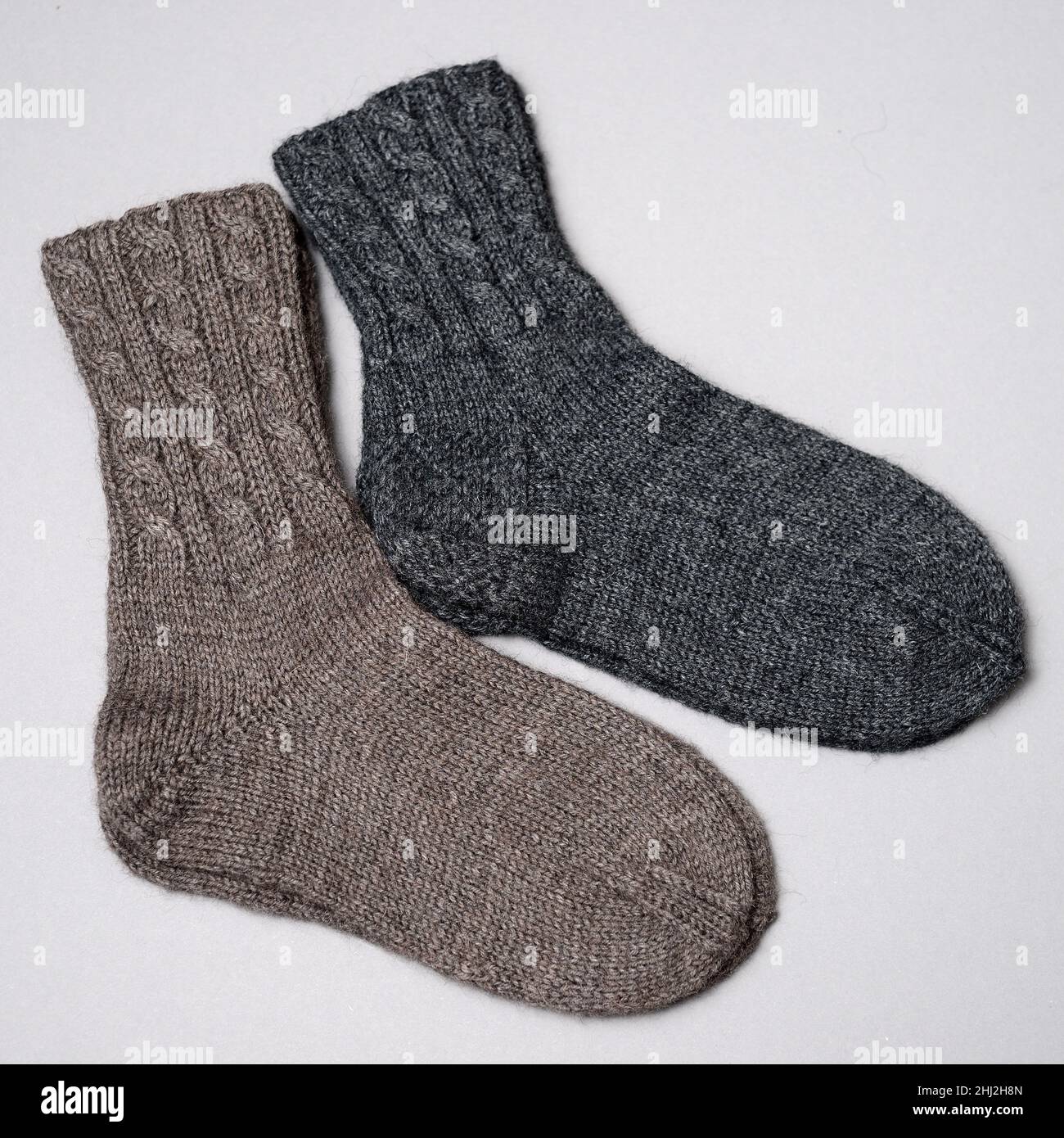 two pair of woolen knitted socks on a gray background Stock Photo