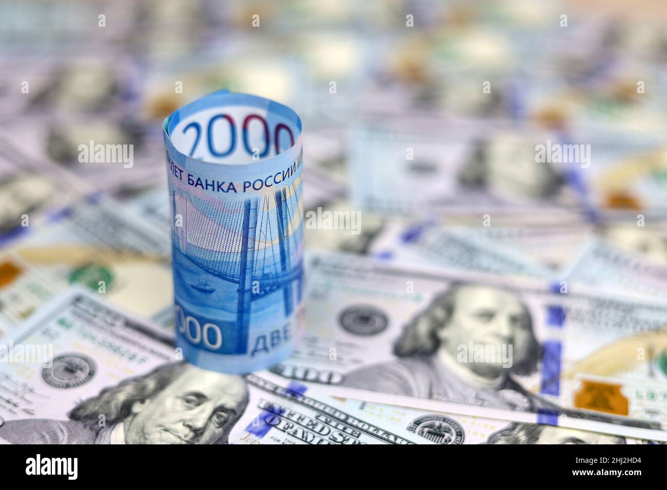 Russian rubles on background of US dollars. Concept of exchange rate, sanctions, falling ruble Stock Photo