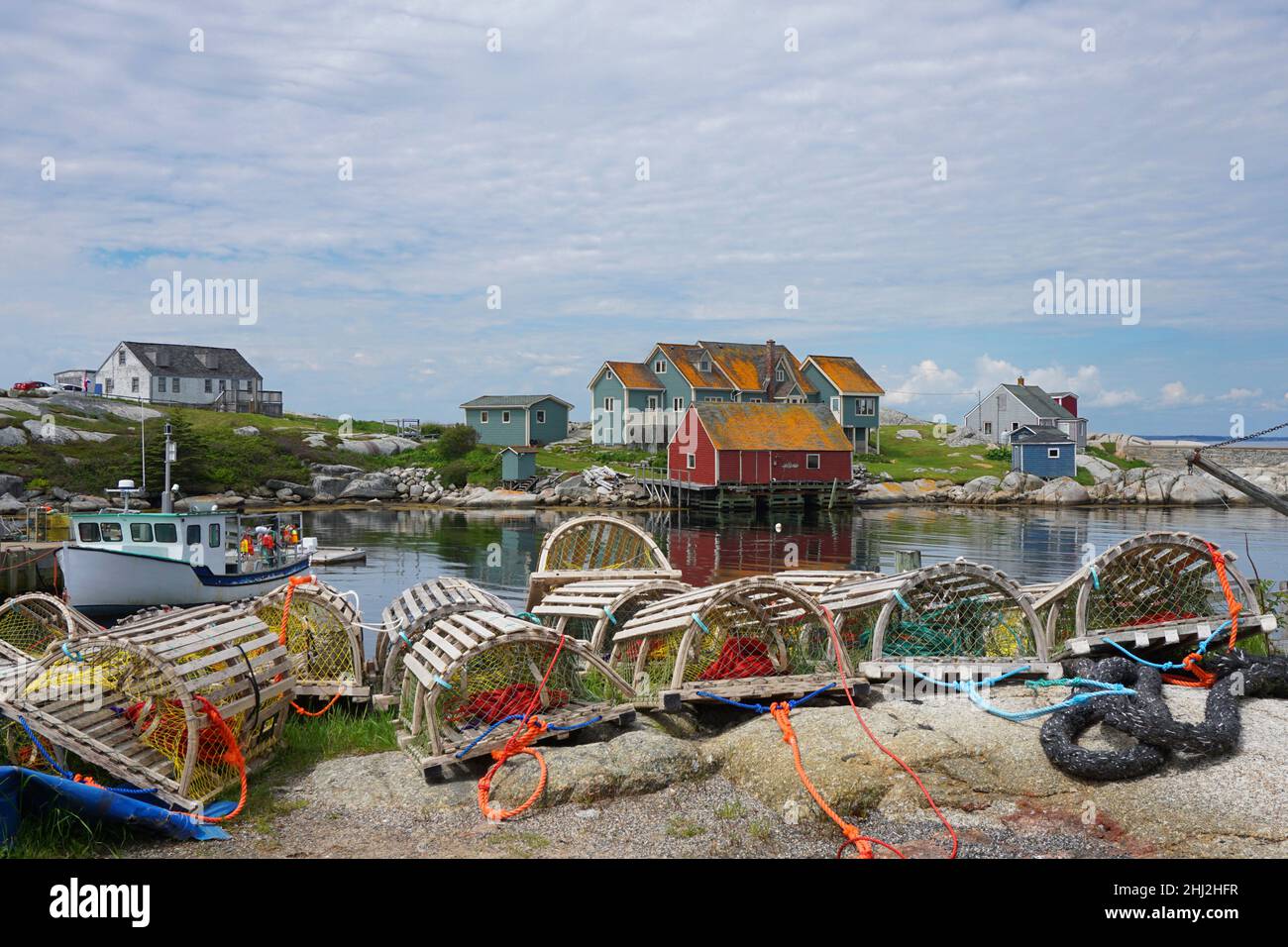 Wooden lobster traps and a fishing boat in Peggys Cove, Nova Scotia, Canada Stock Photo