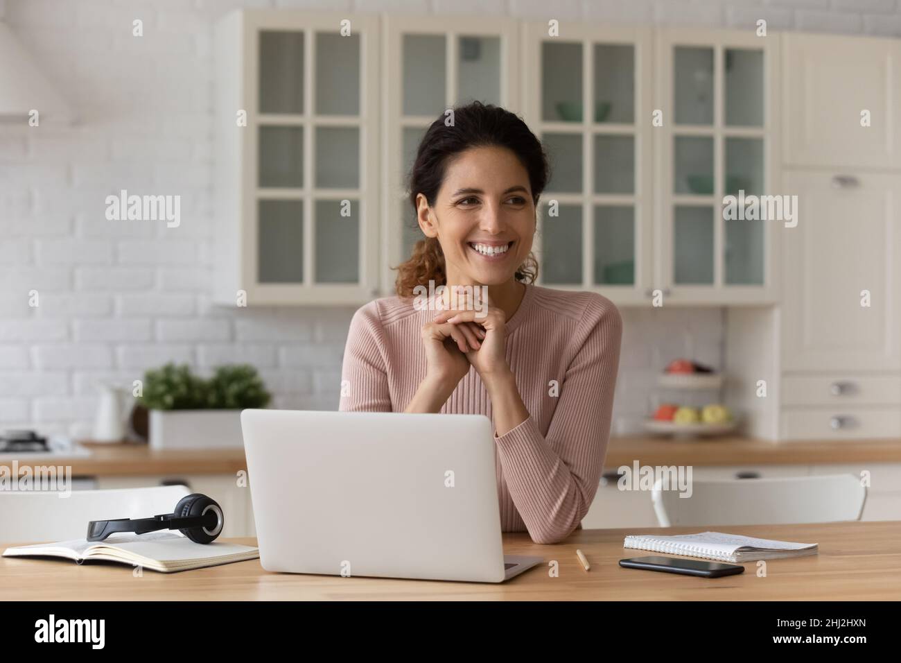 Woman sit at table with laptop take break from telework Stock Photo