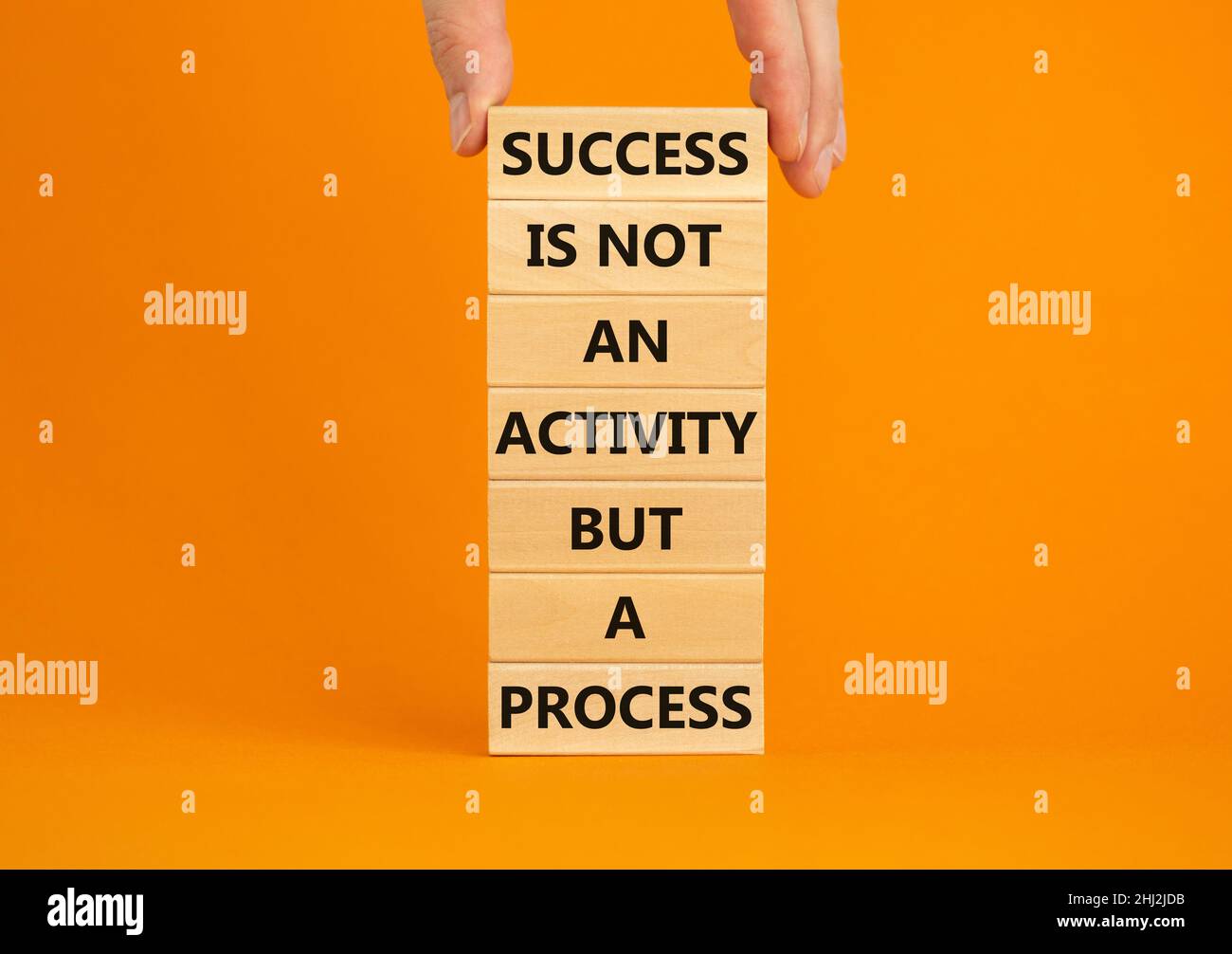 Success in process symbol. Wooden blocks with words Success is not an ...