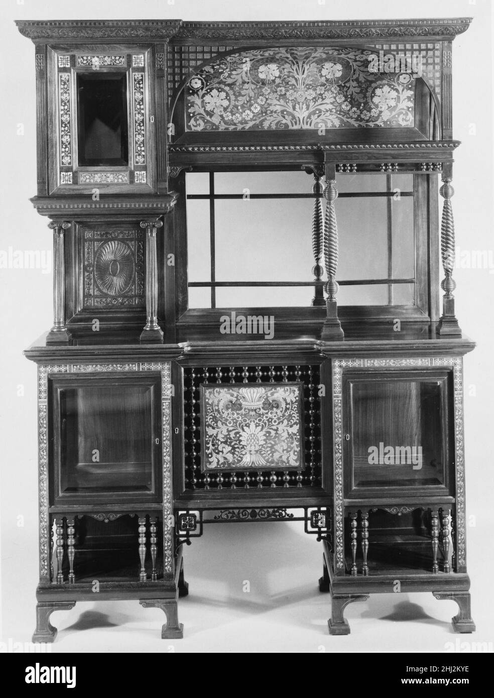 Cabinet ca. 1884 Charles Tisch This cabinet was a gift of its maker, Charles Tisch, to the Metropolitan Museum in 1889. In his offer of the gift, he wrote, 'This piece of Furniture received the first price [sic] at the New Orleans Exposition [18]84/85. It is a purely American production of my own manufacture and consider it worthy of a place in the Museum.' While the cabinet may have been made on American soil, it borrowed design motifs from around the world. Tisch was a German immigrant cabinetmaker living in New York, and his cabinet incorporates Japanese fretwork, Eastlake-inspired spindles Stock Photo