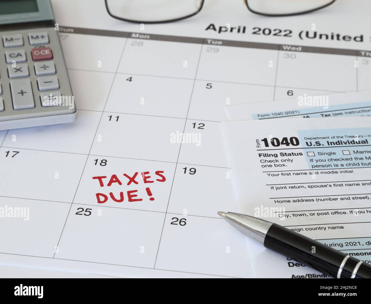 A 2022 calendar noting the April 18 USA Internal Revenue Service IRS income filing deadline for year 2021 taxes is shown up close. Stock Photo