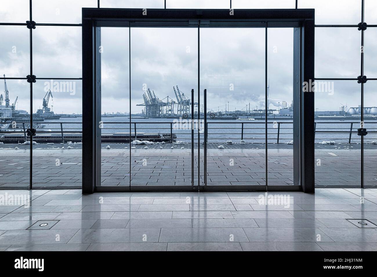 View through modern glass facade with large door onto the harbour, dreary winter weather, Holzhafen Ost office building, Astoc Architekten, Grosse Stock Photo