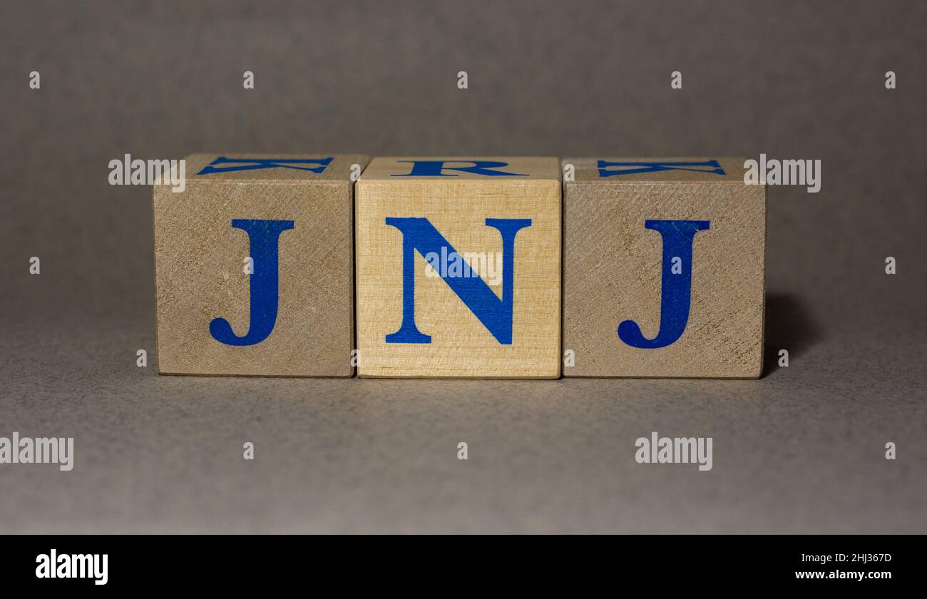 January 19, 2022. New York, USA. Stock Ticker symbol of Johnson & Johnson JNJ, made of wooden cubes, on a gray background. Stock Photo