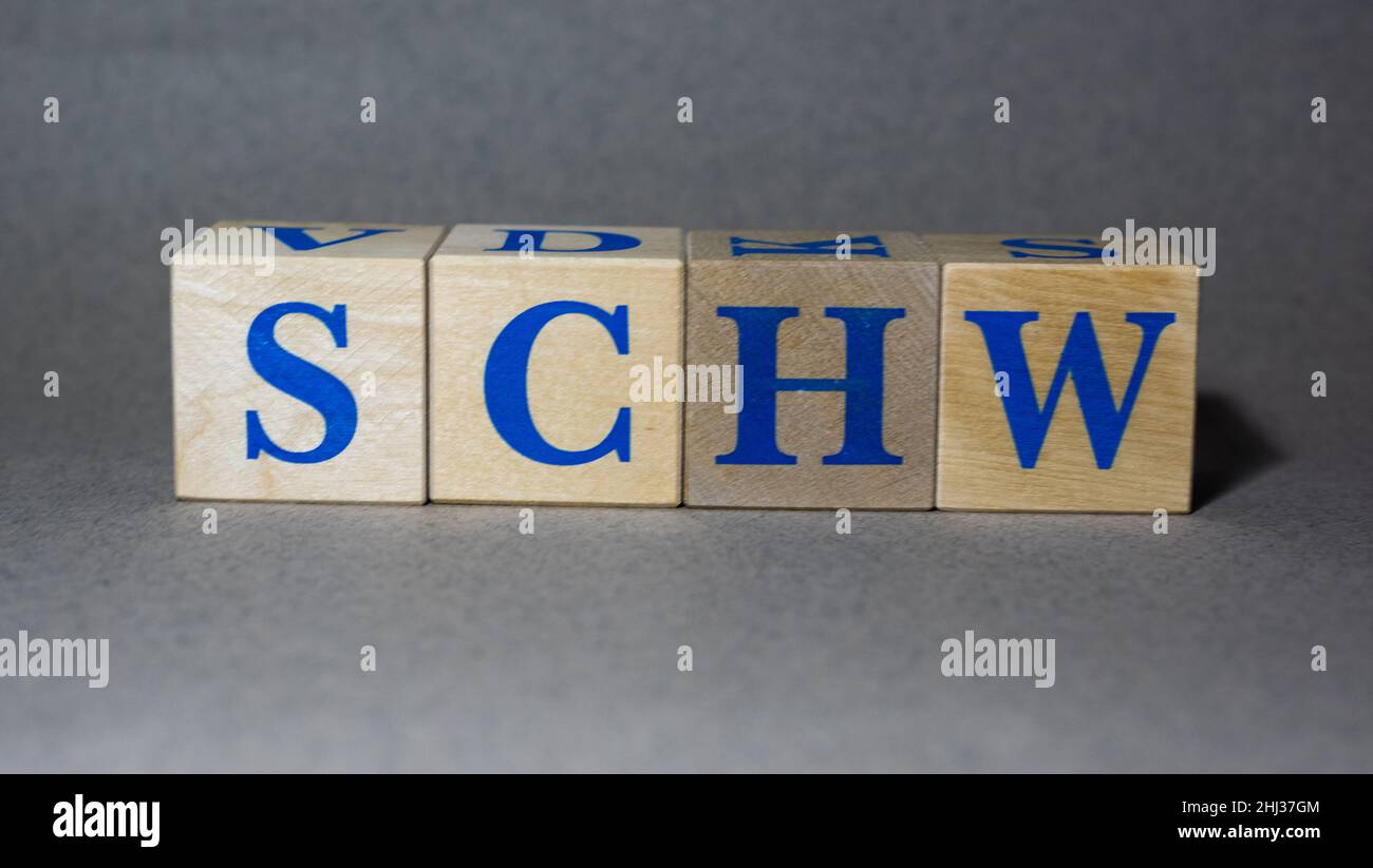 January 19, 2022. New York, USA. Exchange Ticker symbol of The Charles Schwab Corporation SCHW, made of wooden cubes, on a gray background. Stock Photo