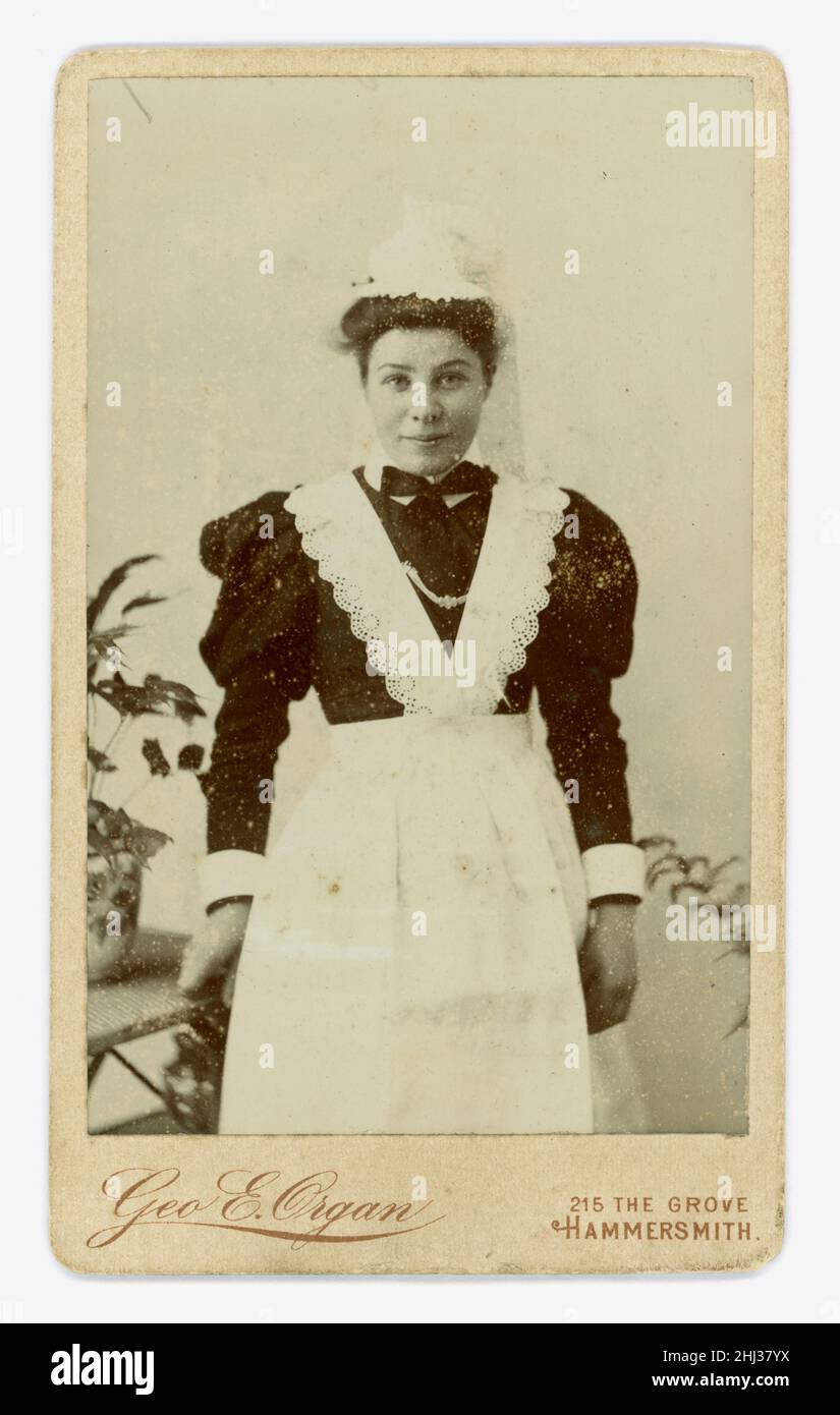 Original Victorian Carted de Visite (CDV) of pretty young maid, wearing a lace cap and apron, puffed sleeves, studio Geo (George) E. Organ, 215 The Grove, Hammersmith,  London, U.K. circa.1898 Stock Photo