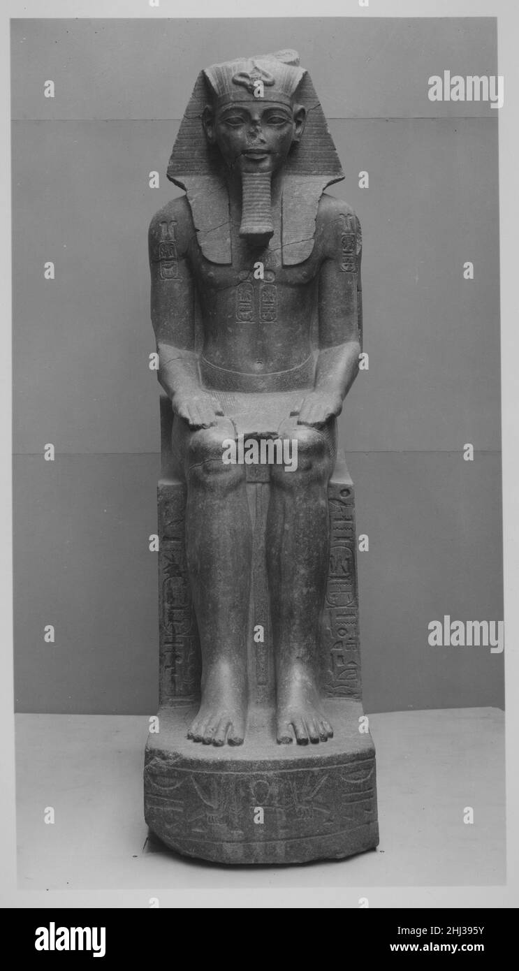 Colossal Seated Statue of Amenhotep III, reworked, reinscribed by Merneptah ca. 1390–1353 B.C. New Kingdom This colossus of Amenhotep III, whose distinctive facial features are still recognizable despite their damaged state, once adorned the temple he built to Amen-Re in Luxor (ancient Thebes). Like so many Dynasty 18 monuments, this statue, along with its partner (22.5.1), was usurped a century and a half later by Merneptah, who had it moved from its original location to the eastern portal of the temple. Merneptah's deeply incised titulary contrasts with the restrained carving of the sema taw Stock Photo