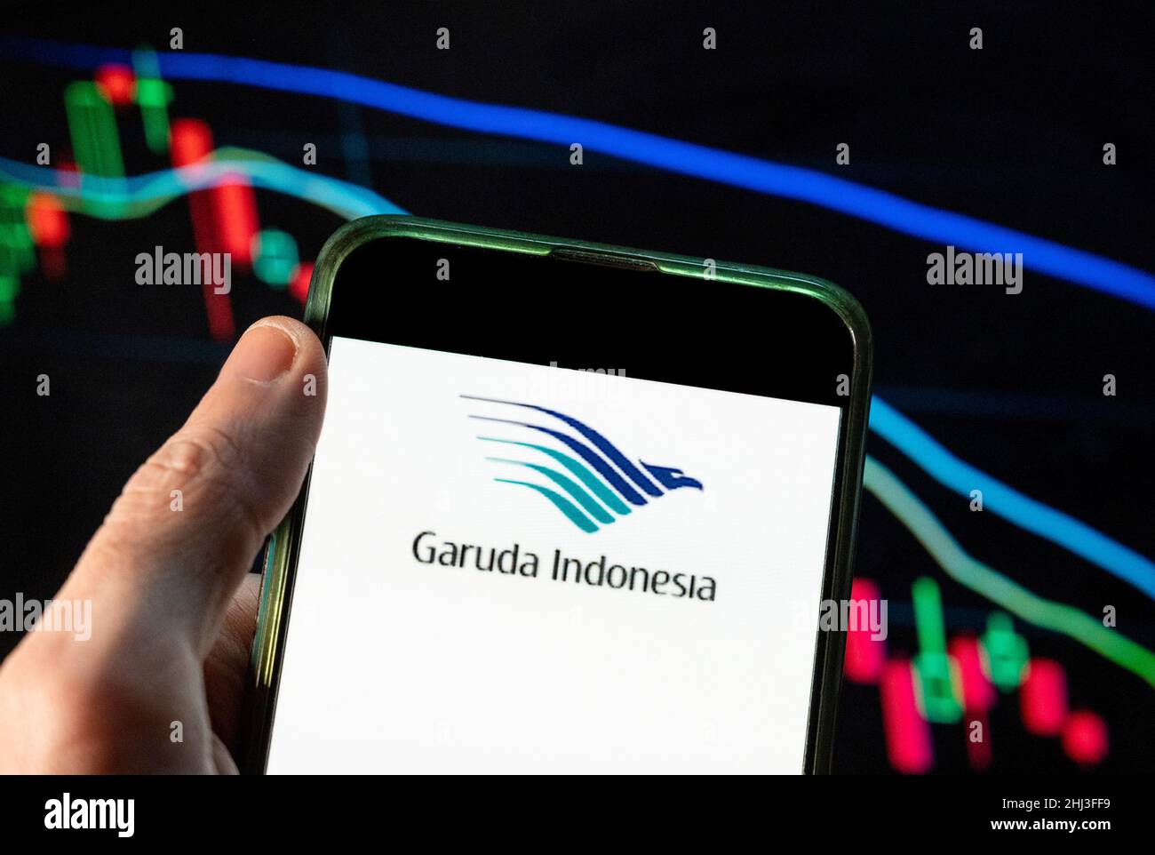 China. 4th Dec, 2021. In this photo illustration the national airline of Indonesia, Garuda Indonesia, logo seen displayed on a smartphone with an economic stock exchange index graph in the background. (Credit Image: © Budrul Chukrut/SOPA Images via ZUMA Press Wire) Stock Photo
