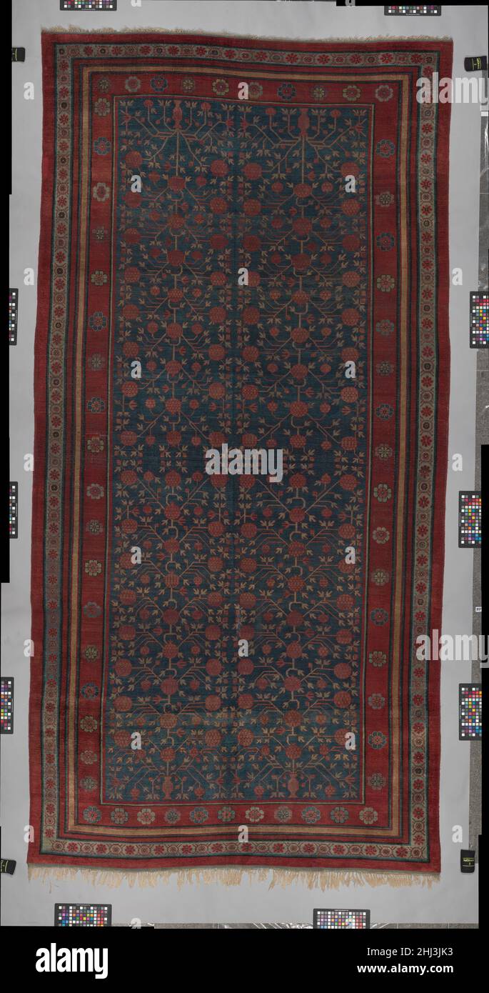 Carpet late 18th–early 19th century Carpets woven in the former silk road settlements of Kashgar, Yarkand, and Khotan, situated at the western end of the Taklamakan Desert, display a mixture of patterns and styles. Chinese influence can be seen in the palette–with emphasis on deep red, blue, and yellow–and in some patterns, particularly those of the borders. Field patterns typically draw from Iranian or Central Asian Turkic or even Mughal Indian traditions. The knot type is the asymmetrical knot favored in Iran. This rug bears one of the more popular patterns found in these carpets, the vase a Stock Photo