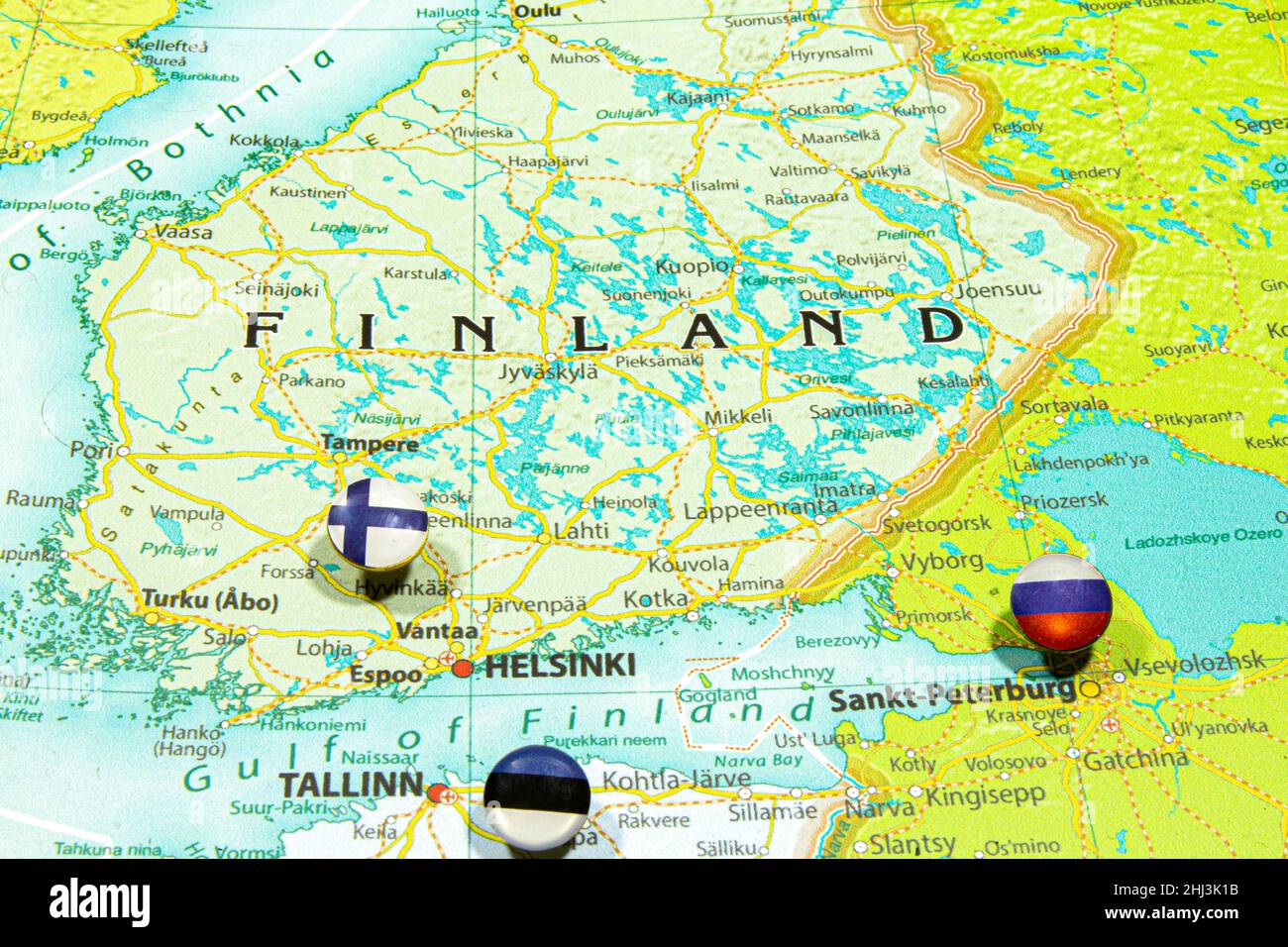 Finland national flag pinned on Europe map. Macro Close up picture of country on a colorful and Blurry World Map Globe with focus to capital Helsinki. Stock Photo