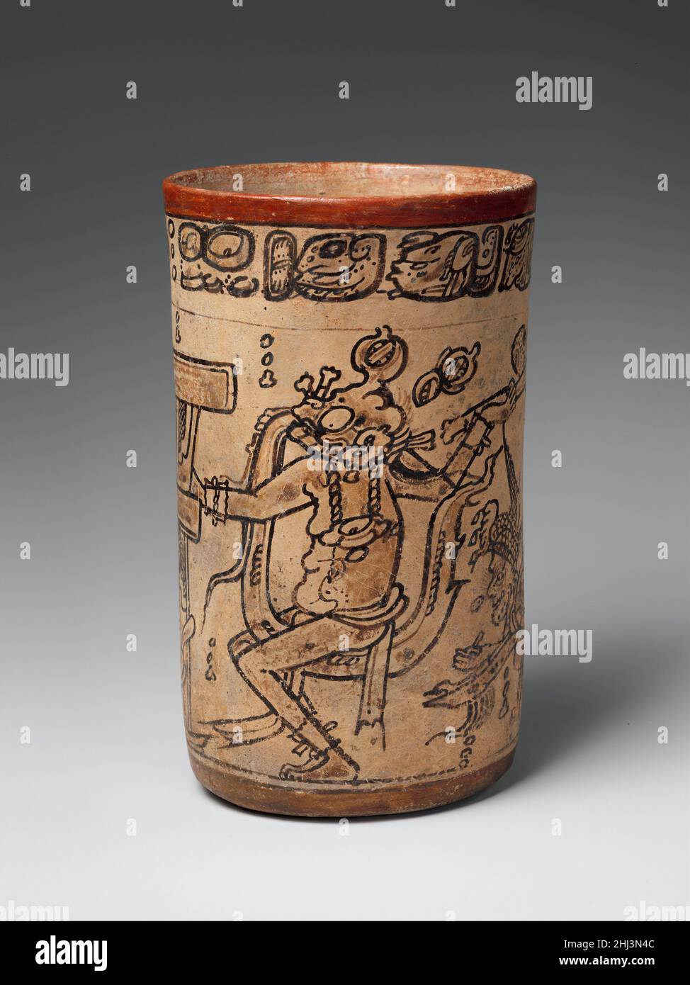 Codex-Style Vase with Mythological Scene ca. 7th or 8th century Maya This drinking cup, painted in what is known as the codex style, shows a unique scene from the corpus of Maya ceramic paintings. The protagonist is an aging Rain God, known by the name Chahk in the hieroglyphic script, who wields a ceremonial ax in his left hand while placing his right hand on a stone temple or palace that he has presumably split open. The “grape-bunch” motif located to the right of the cleft on the temple’s facade signifies that the building is made of stone, and four half-quatrefoil motifs marked with crossh Stock Photo