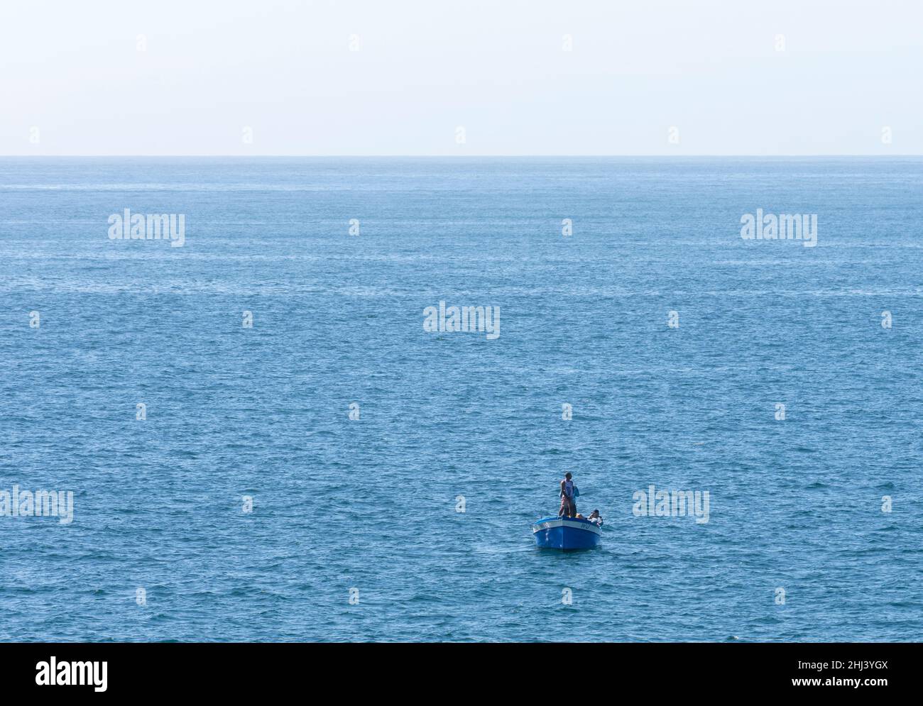 Fishermen on a tiny boat in the middle of the ocean Stock Photo - Alamy