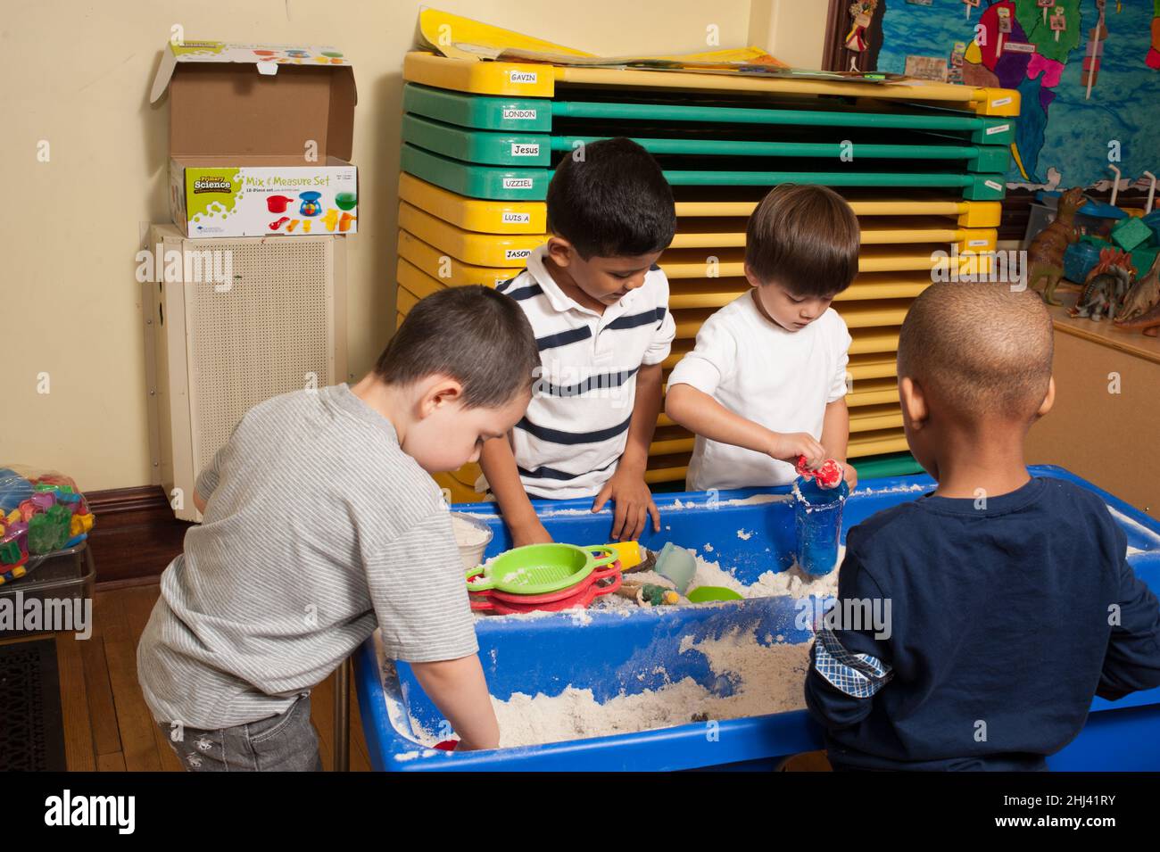 Education Preschool group of boys playing at sand table Stock Photo