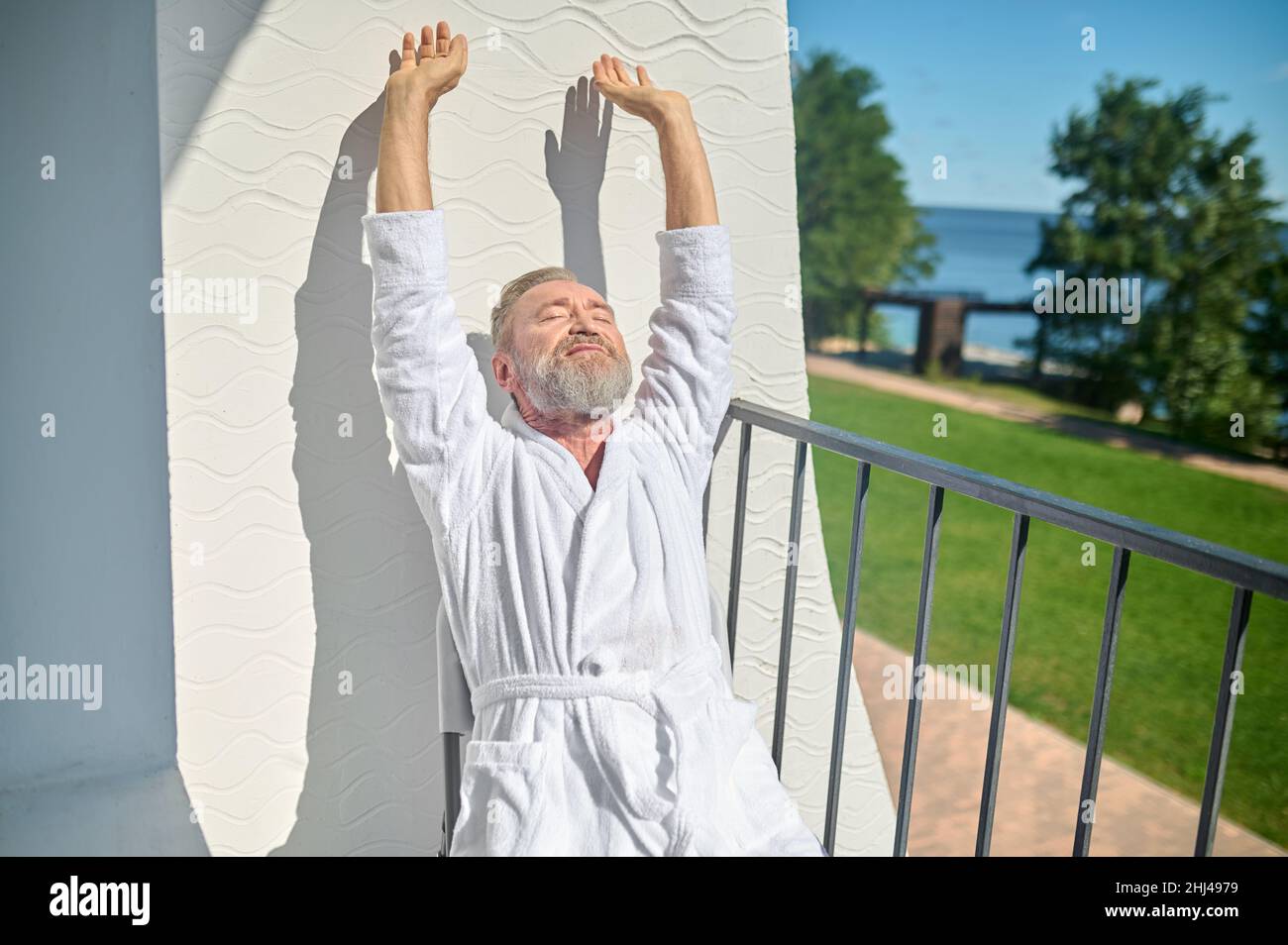 Relaxed gray-haired man basking in the sunshine Stock Photo